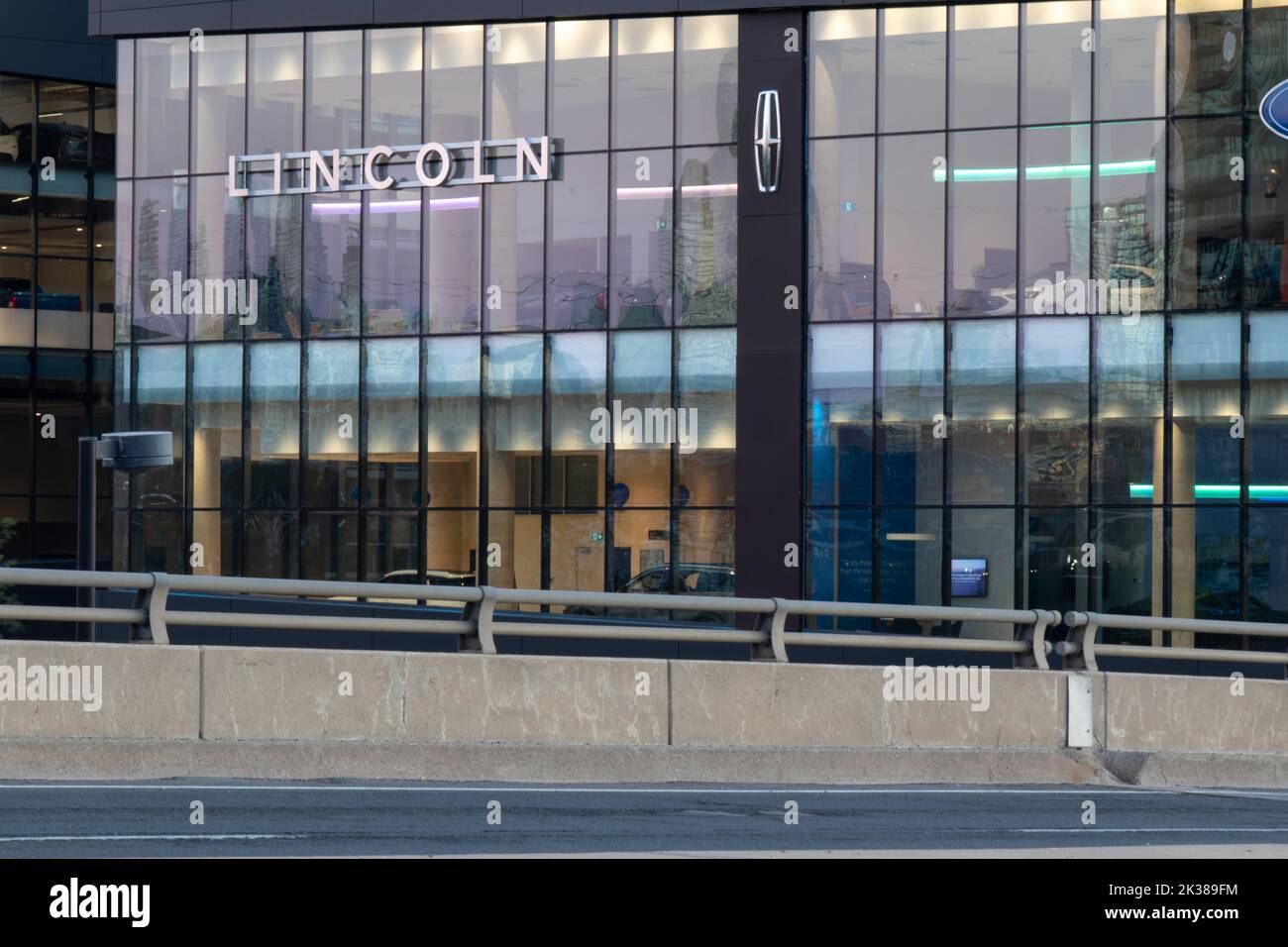 The Lincoln logo on the side of a downtown Toronto dealership while illuminated at dawn. Stock Photo