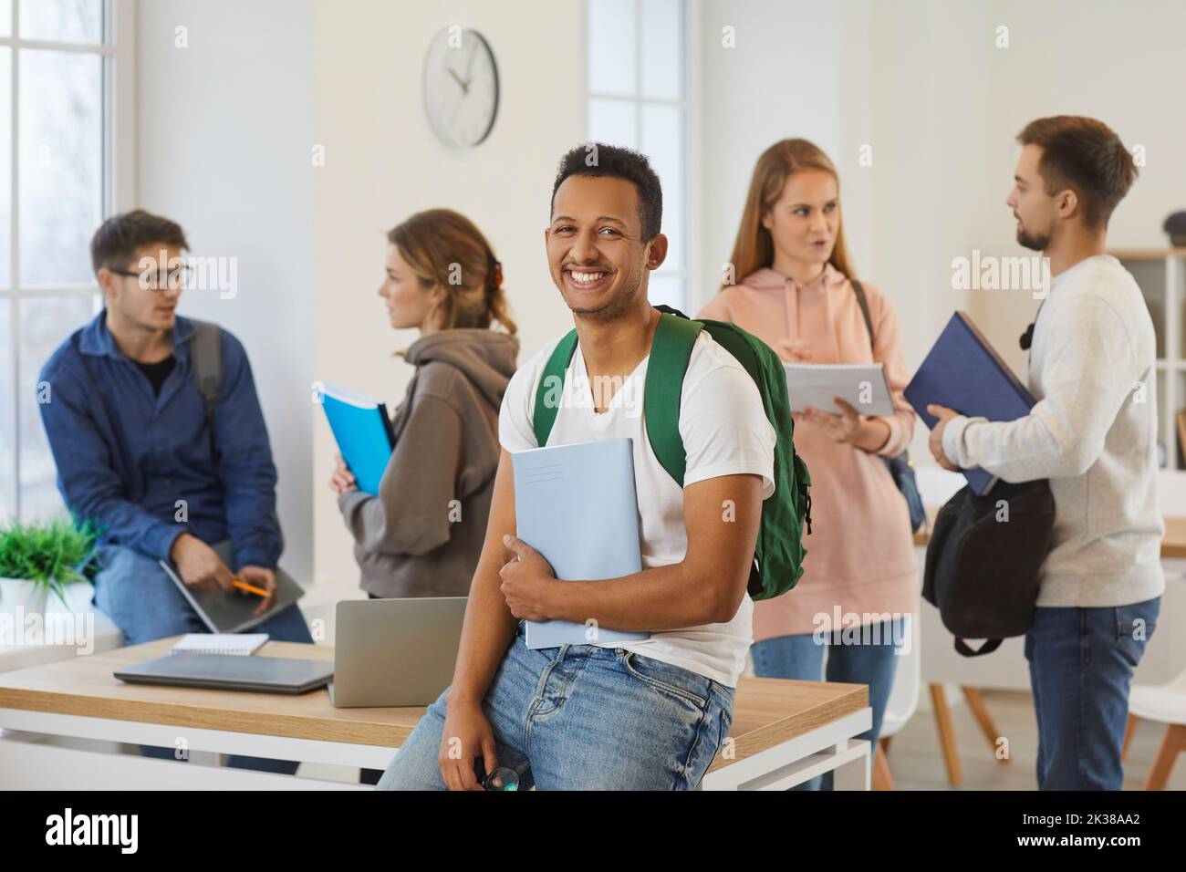 Portrait of smiling ethnic guy student in classroom Stock Photo