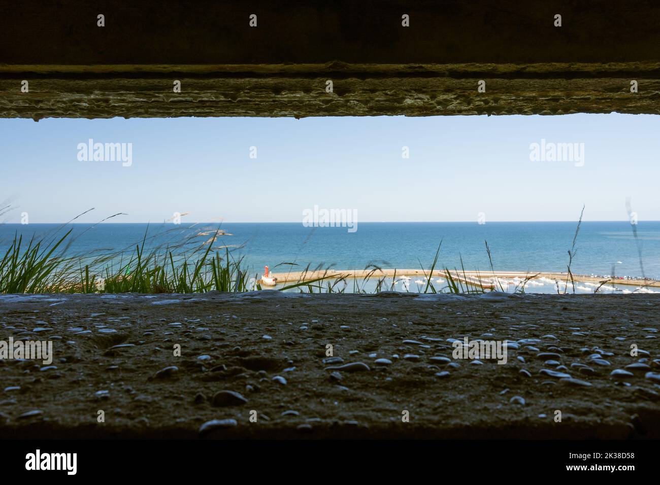 View out from one of the Atlantic sea wall defence bunkers near Port-en-Bessin, Normandie Stock Photo