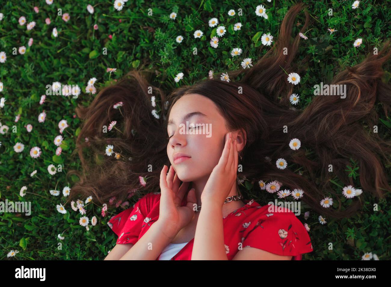 Young beautiful girl resting on fresh spring grass Stock Photo