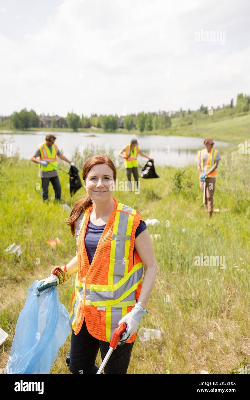 Portrait of woman litter picking next to lake Stock Photo Alamy