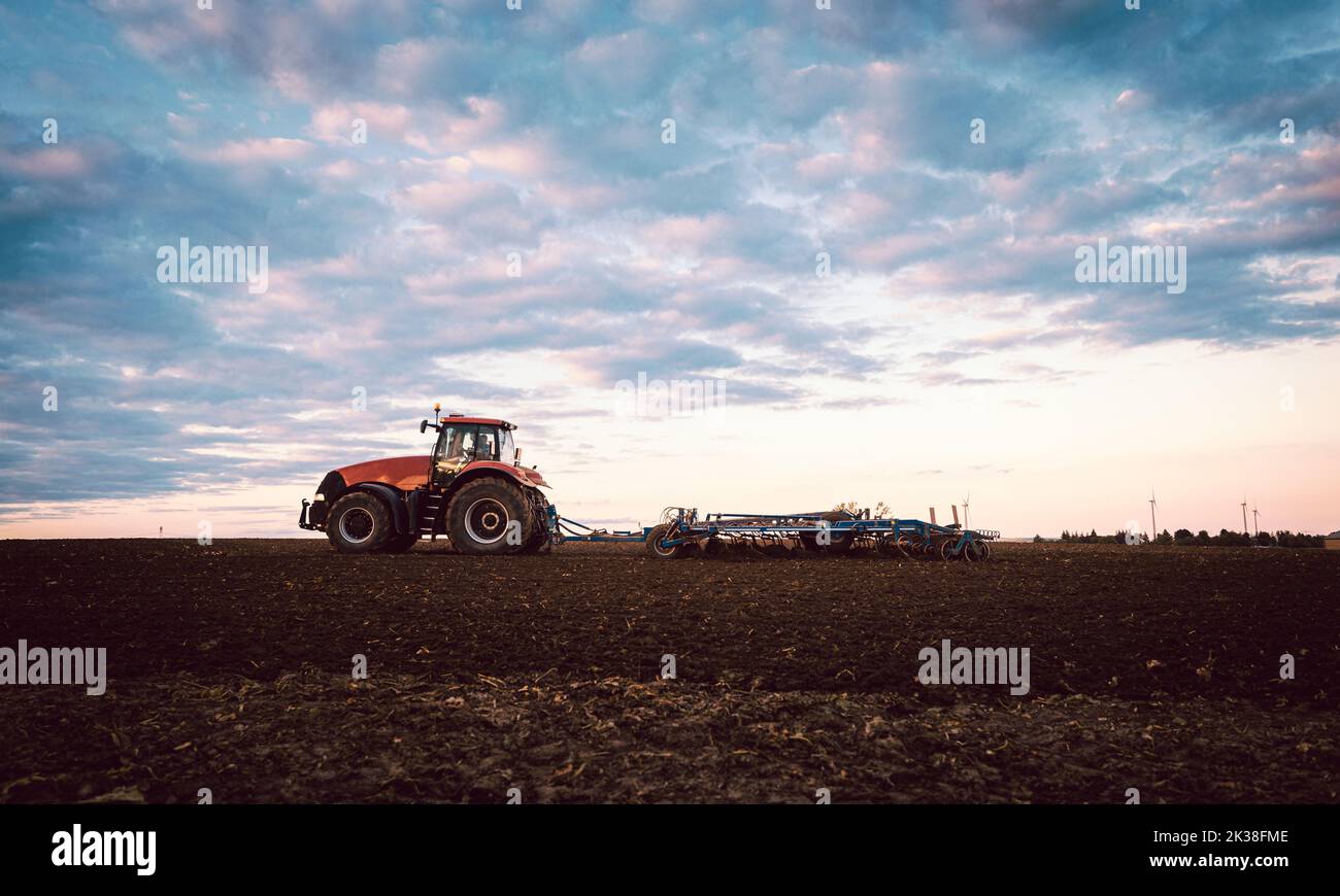 Tractor on field tilling the soil Stock Photo