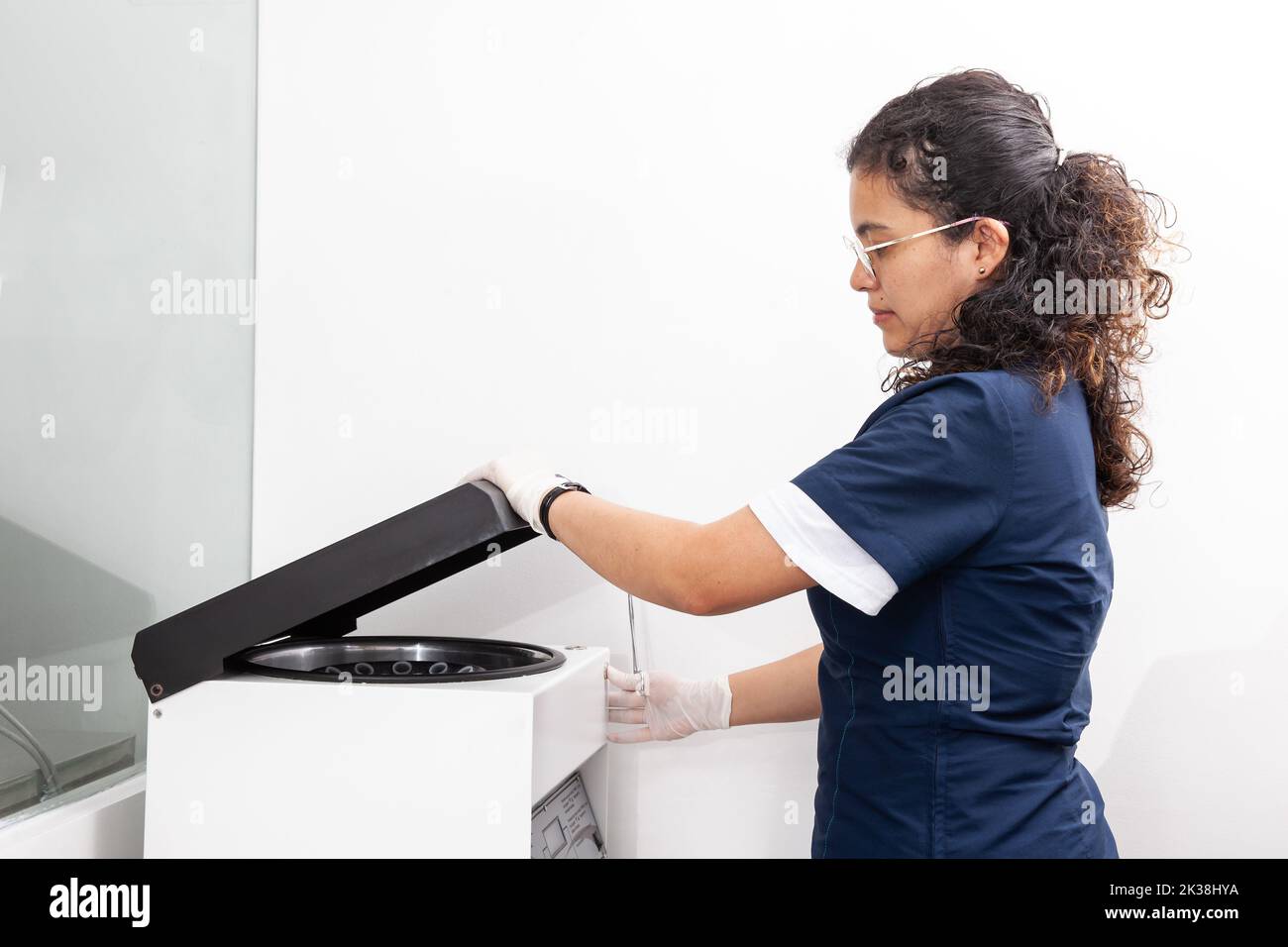 Young female scientist using a centrifuge in the laboratory. Stock Photo
