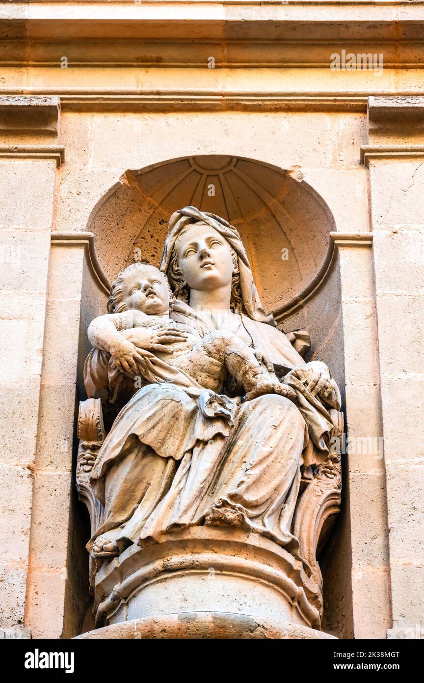 Stone sculpture of a religious saint decorating the facade of the famous medieval building Stock Photo