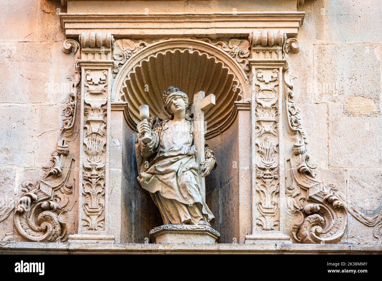 Stone sculpture of a religious saint decorating the facade of the famous medieval building Stock Photo
