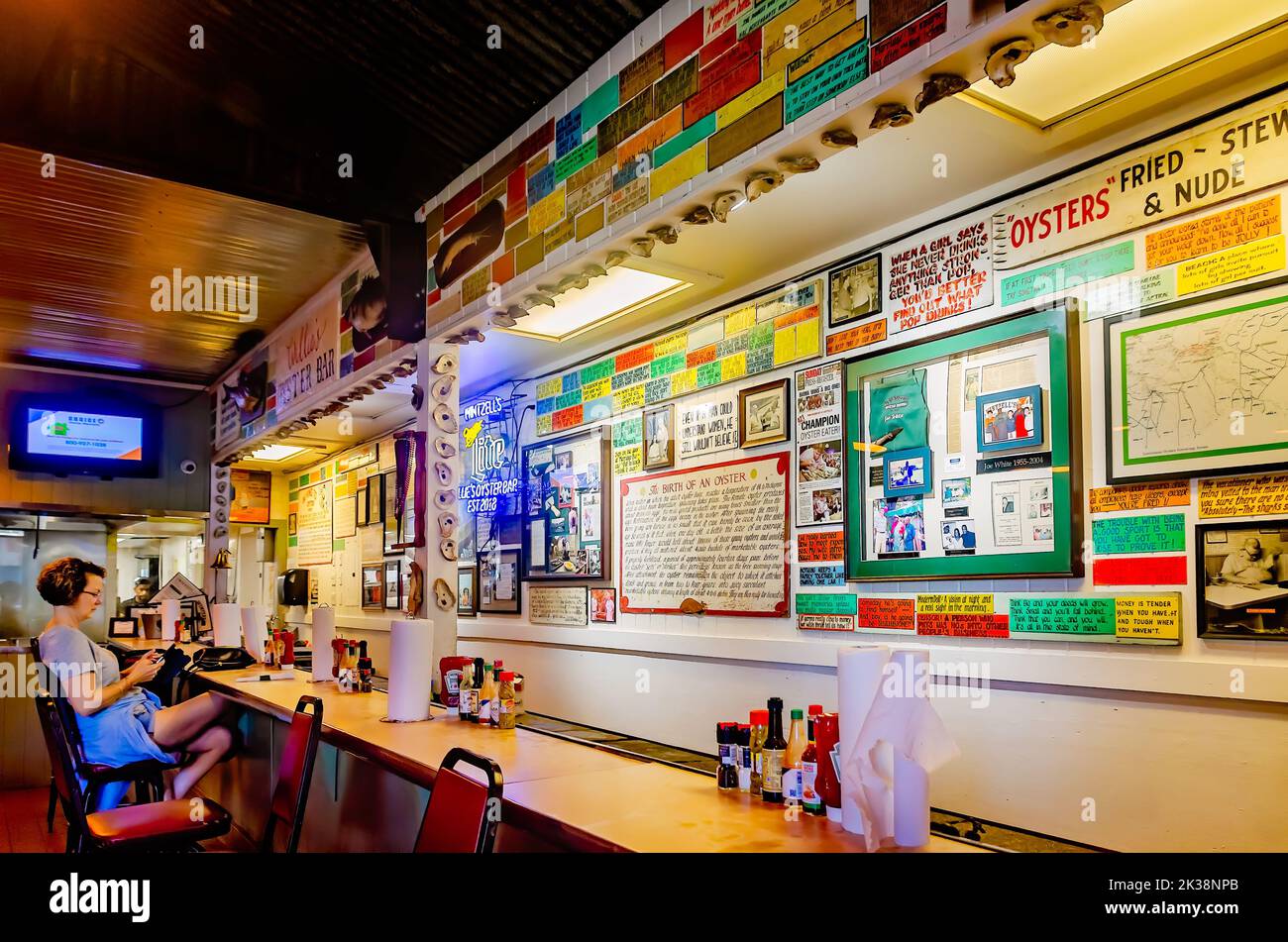 A tourist sits at the oyster bar in Wintzell’s Oyster House on Dauphin