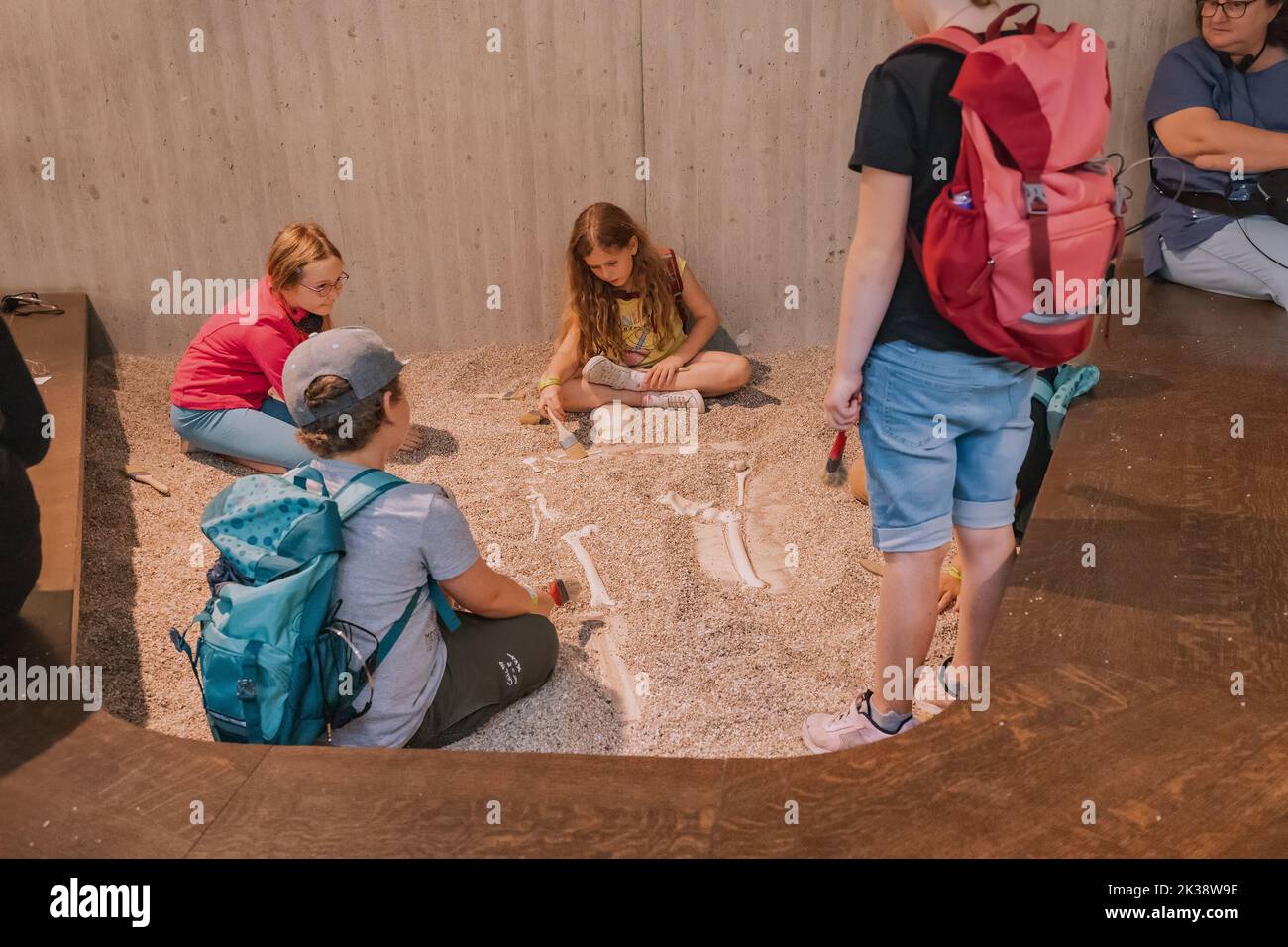 22 July 2022, Neanderthal museum, Germany: children play archaeologists dig up a Neanderthal skeleton during a museum tour Stock Photo