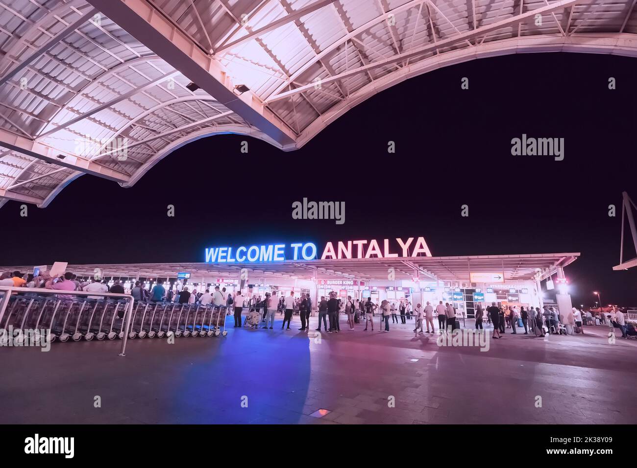 17 July 2022, Antalya, Turkey: Welcome to Antalya sign at the arrival international terminal of Airport with crowds of tourists at night. Huge tourist Stock Photo
