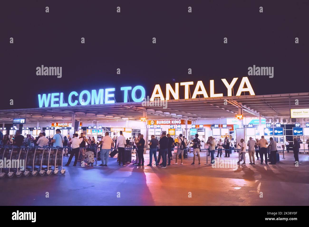 17 July 2022, Antalya, Turkey: Welcome to Antalya sign at the arrival international terminal of Airport with crowds of tourists at night. Huge tourist Stock Photo