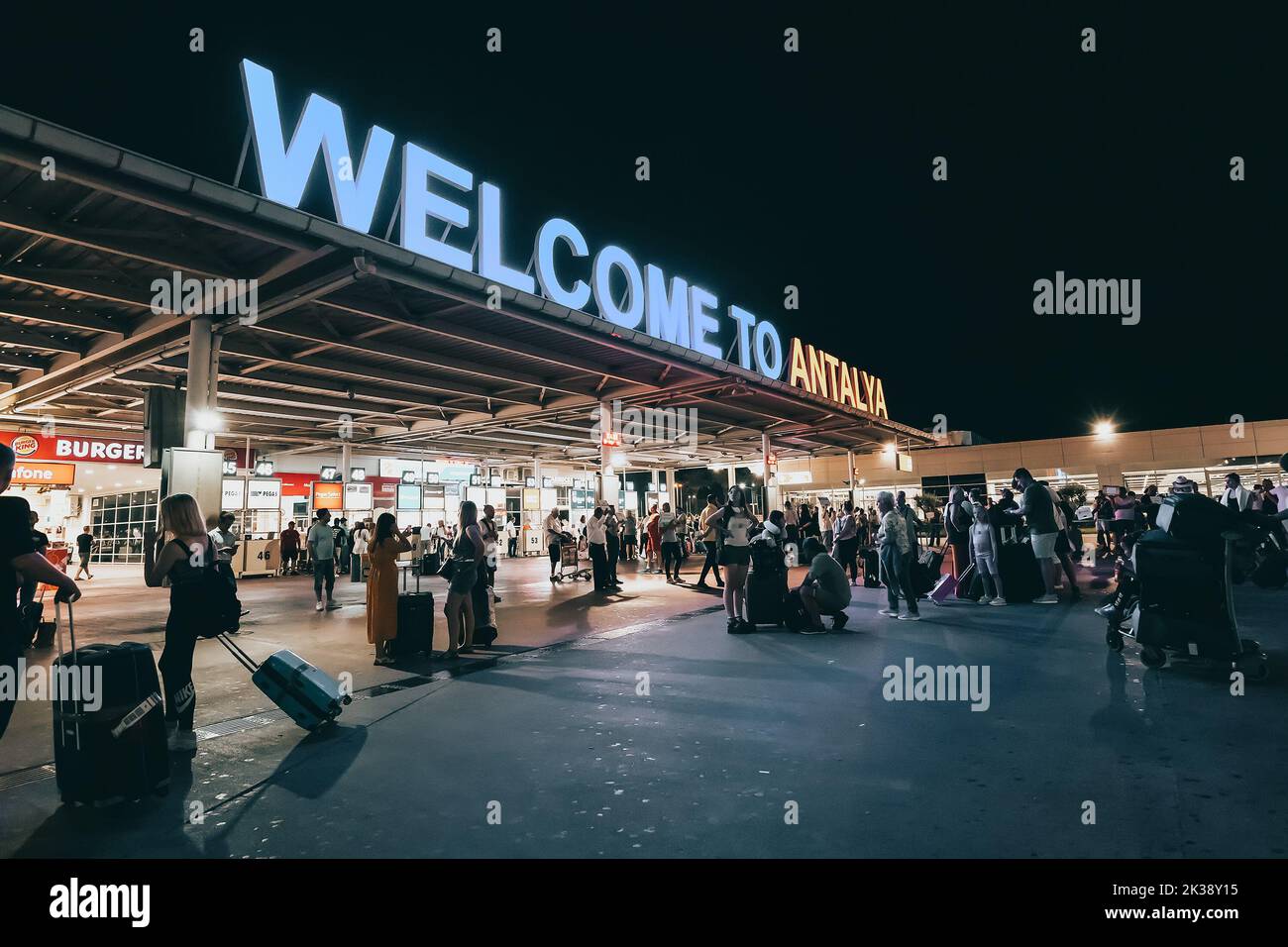 17 July 2022, Antalya, Turkey: Welcome to Antalya sign at the arrival international terminal of Airport with crowds of tourists at night. Huge tourist Stock Photo