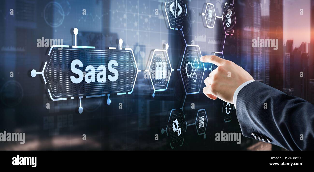 SaaS Software as a Service concept with man hand pressing text. Stock Photo