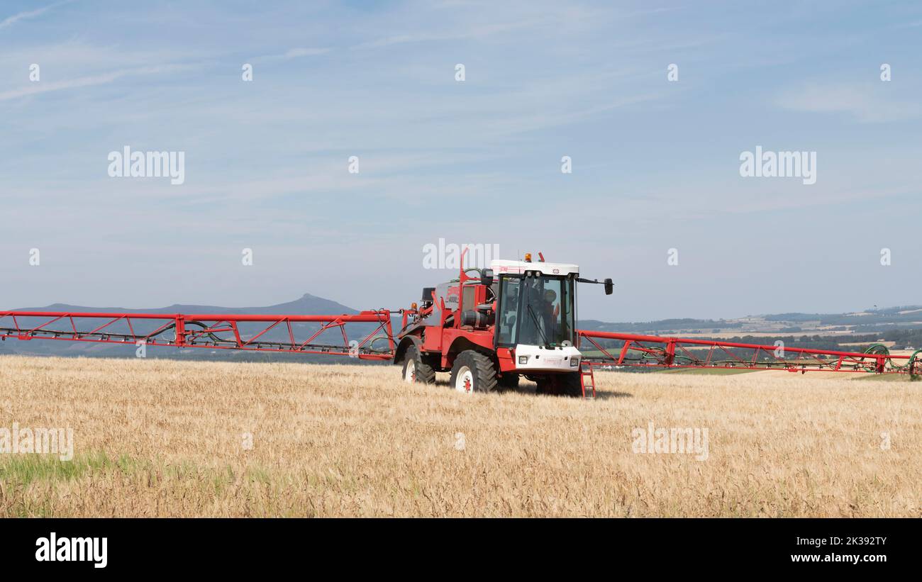 Crop Spraying in a Field of Barley in Summer with a Bateman Self Propelled Sprayer Stock Photo