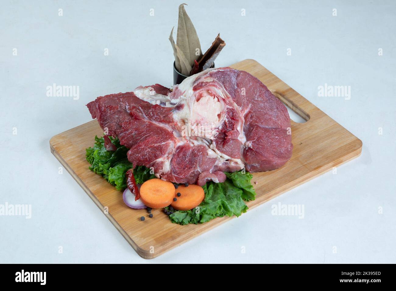 Raw beef steak with rosemary and spices on wooden board Stock Photo