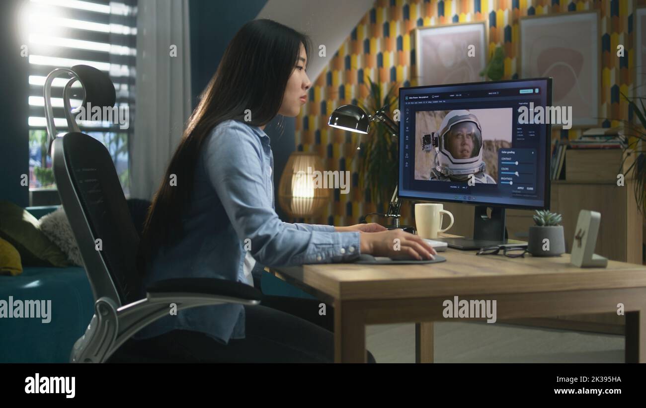 Female asian freelancer editing picture with astronaut on computer in ...
