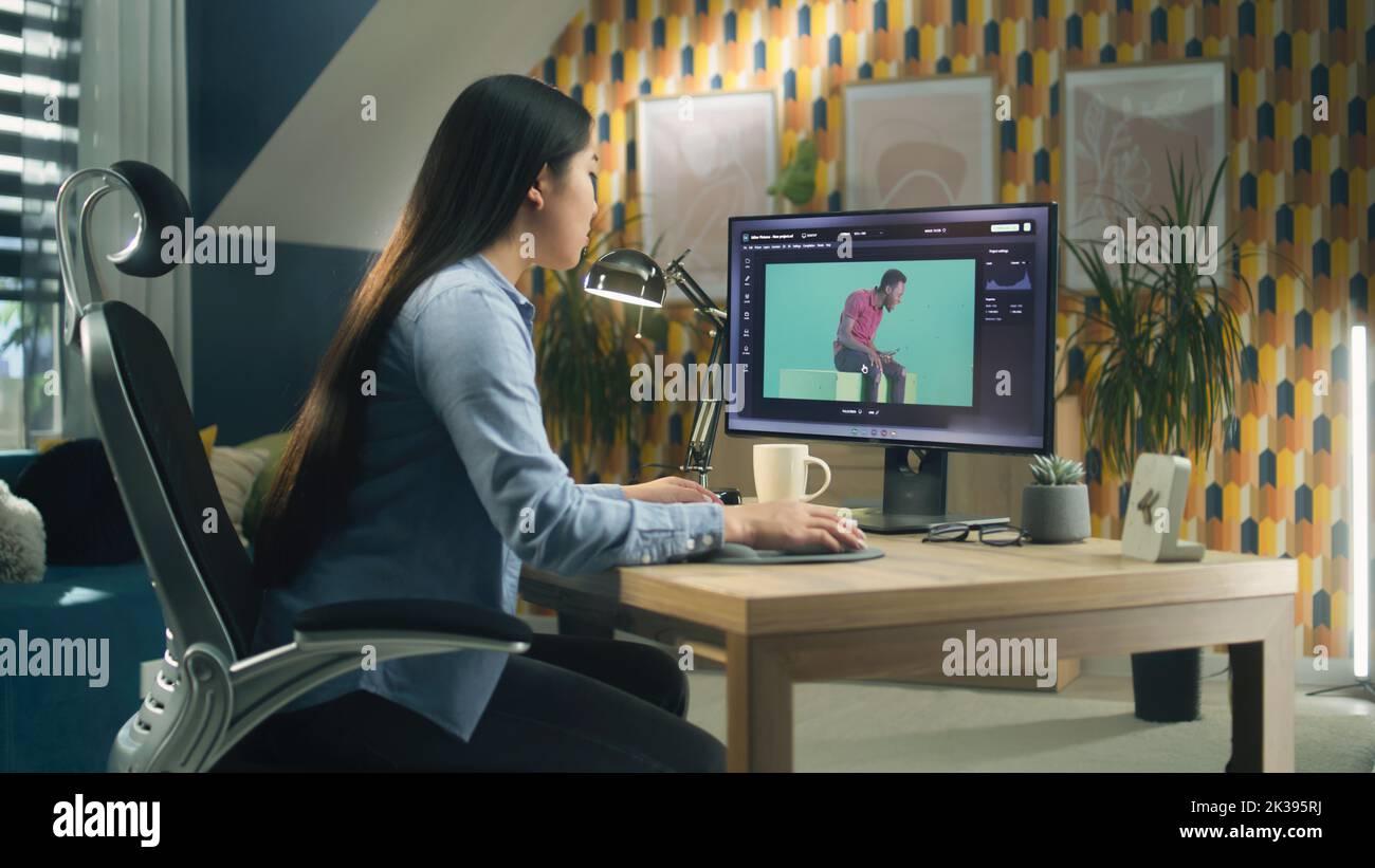 Asian woman editing photo in photoshop for customer on personal computer while sitting at the table at home office and working remotely Stock Photo