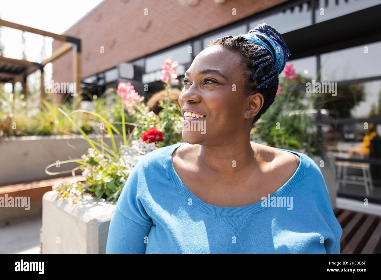 Close up of cheerful woman with cornrow hair at terrace Stock Photo