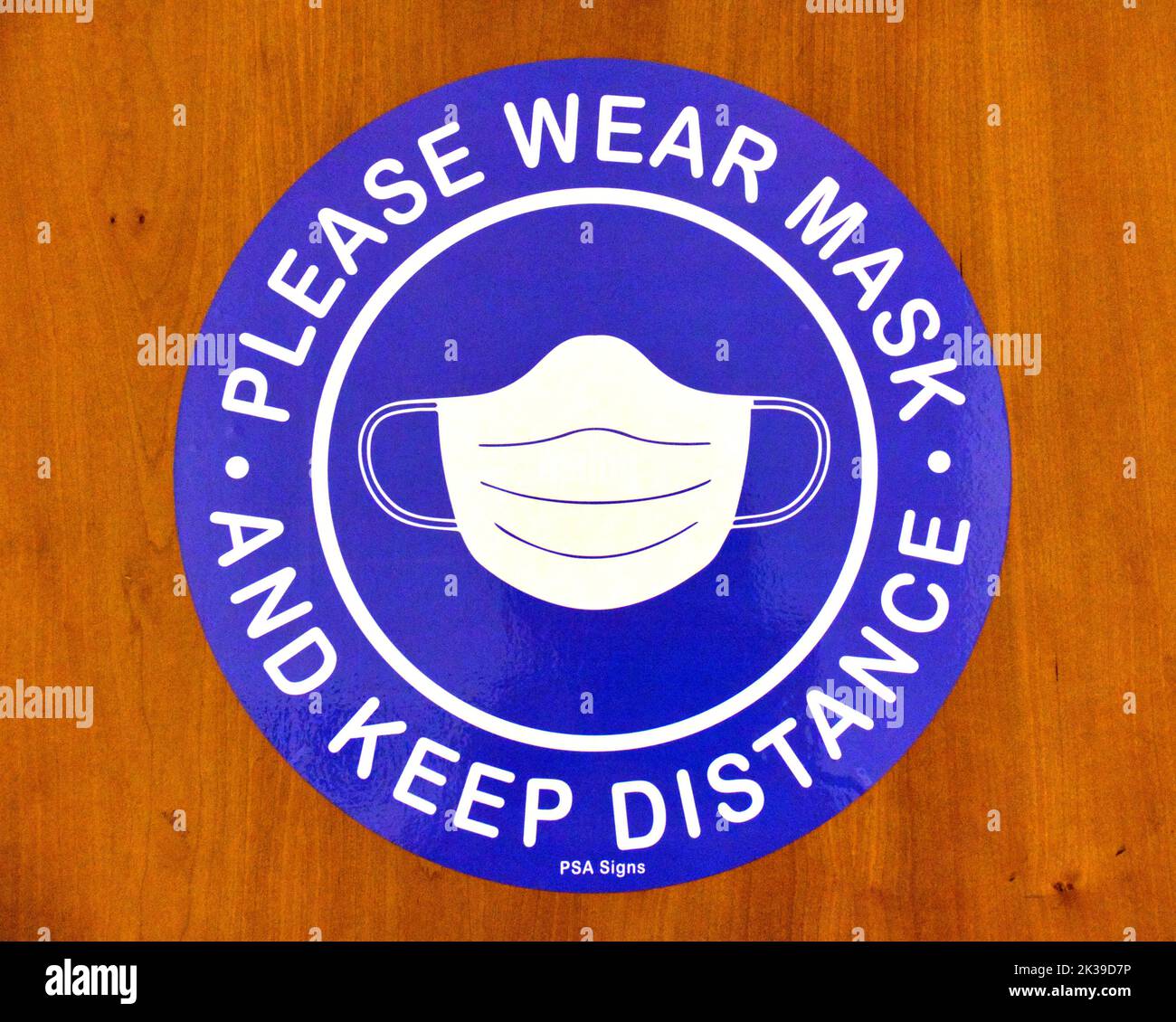 please wear mask and keep distance sign on door Stock Photo