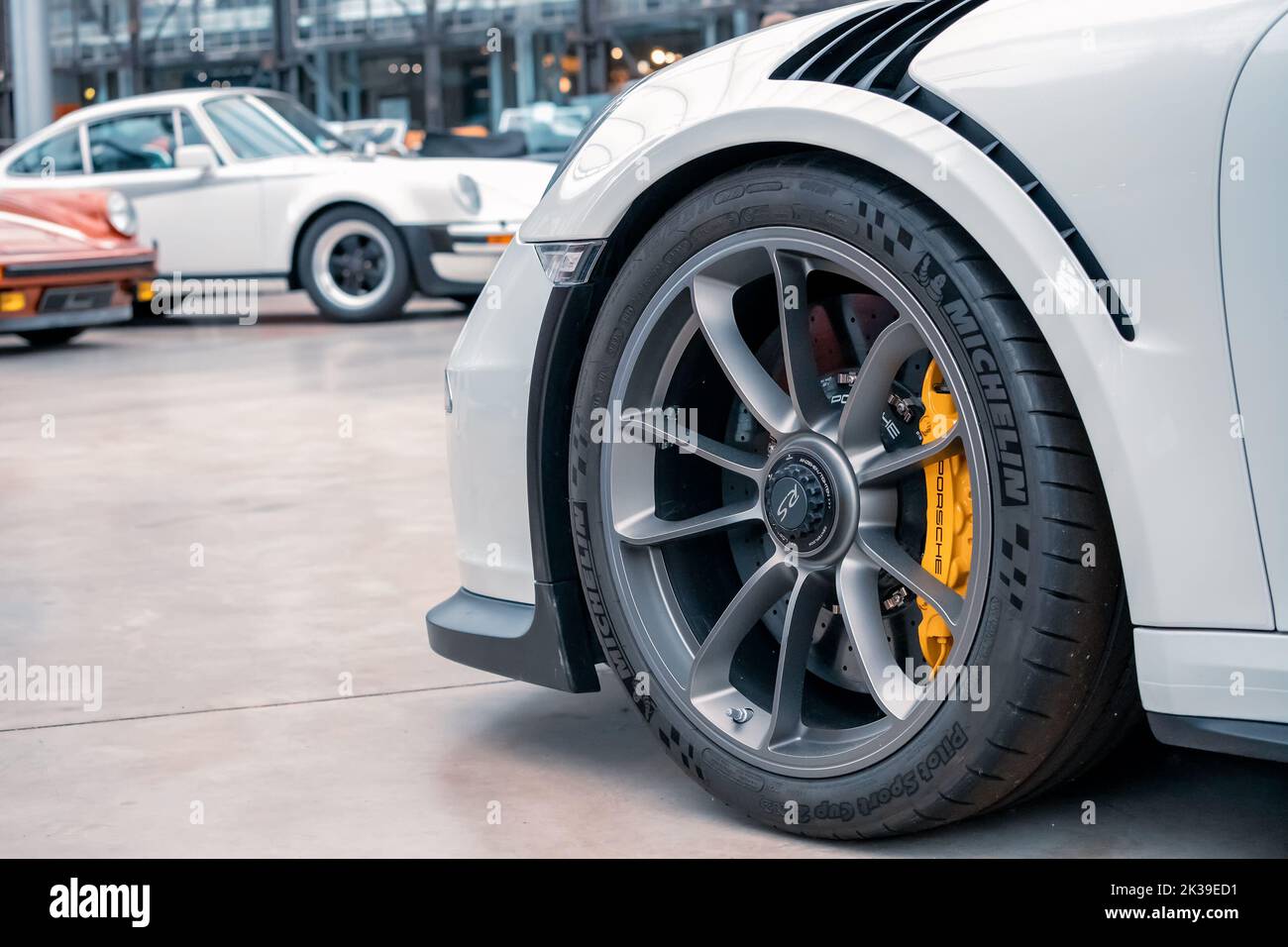 21 July 2022, Dusseldorf, Germany: The wheel and tire of a luxury Porsche sports car with a powerful braking system and discs. Stock Photo