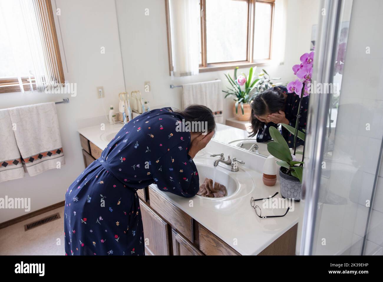 Senior woman washing face at bathroom sink Stock Photo Alamy