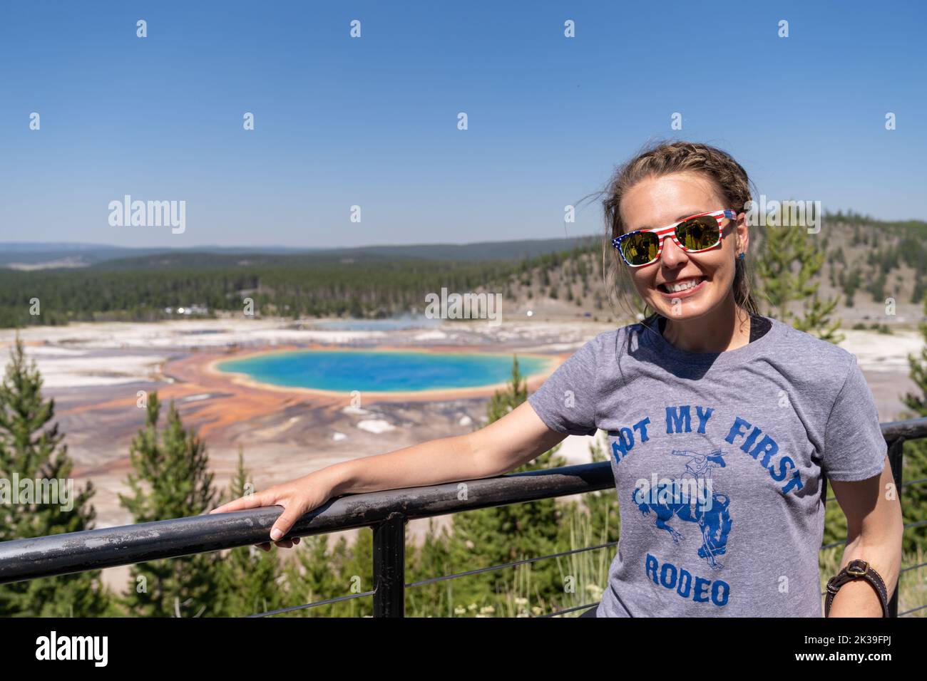 Wyoming, USA - July 19, 2022: Cute woman tourist poses at the overlook for Grand Prismatic Spring in Yellowstone National Park Stock Photo