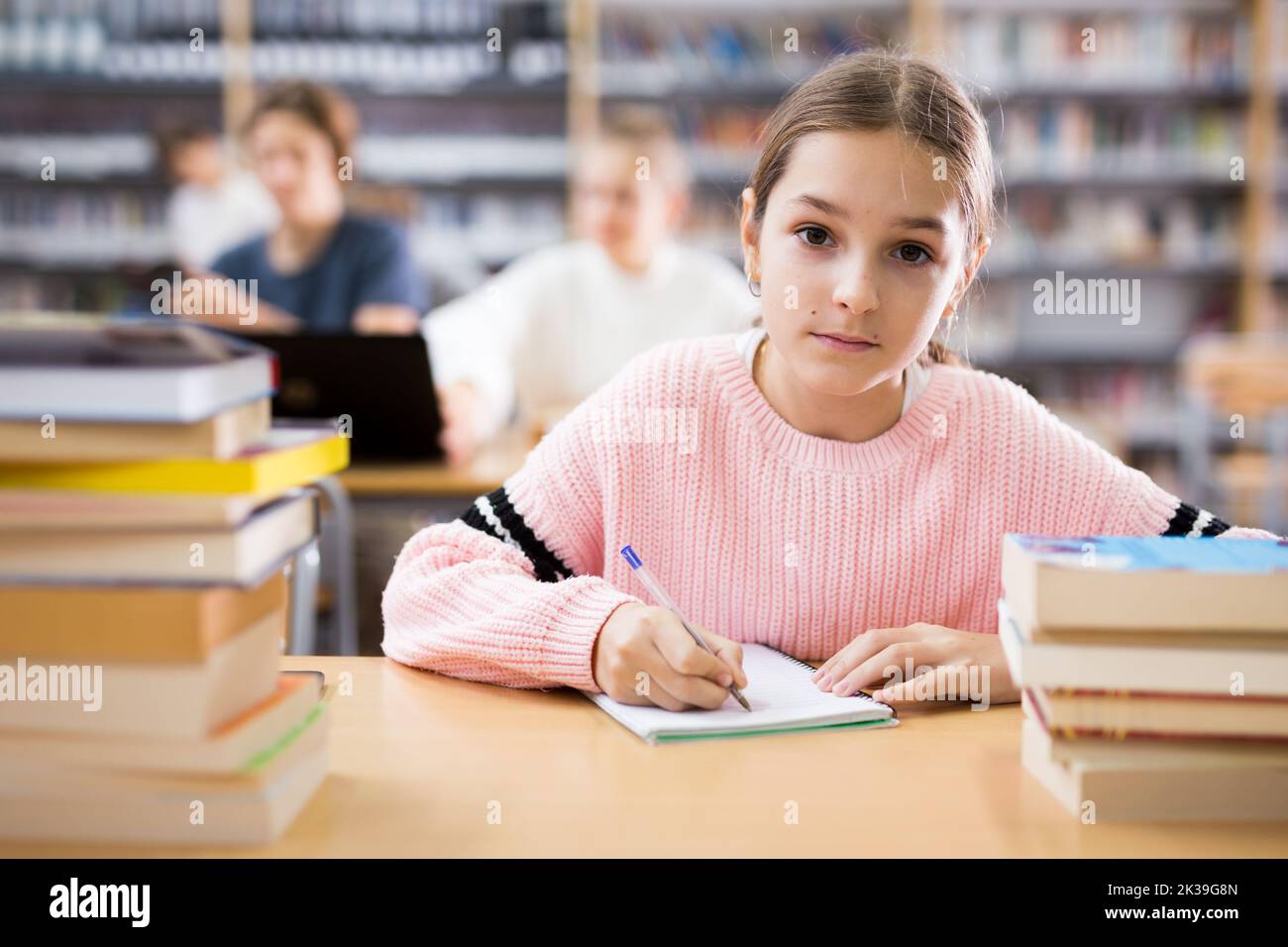 Library Do Homework Young girl doing homework in library Stock Photo - Alamy
