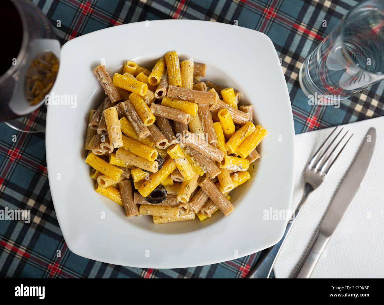 Traditional rigatoni pasta with chopped bacon and cream sauce in plate