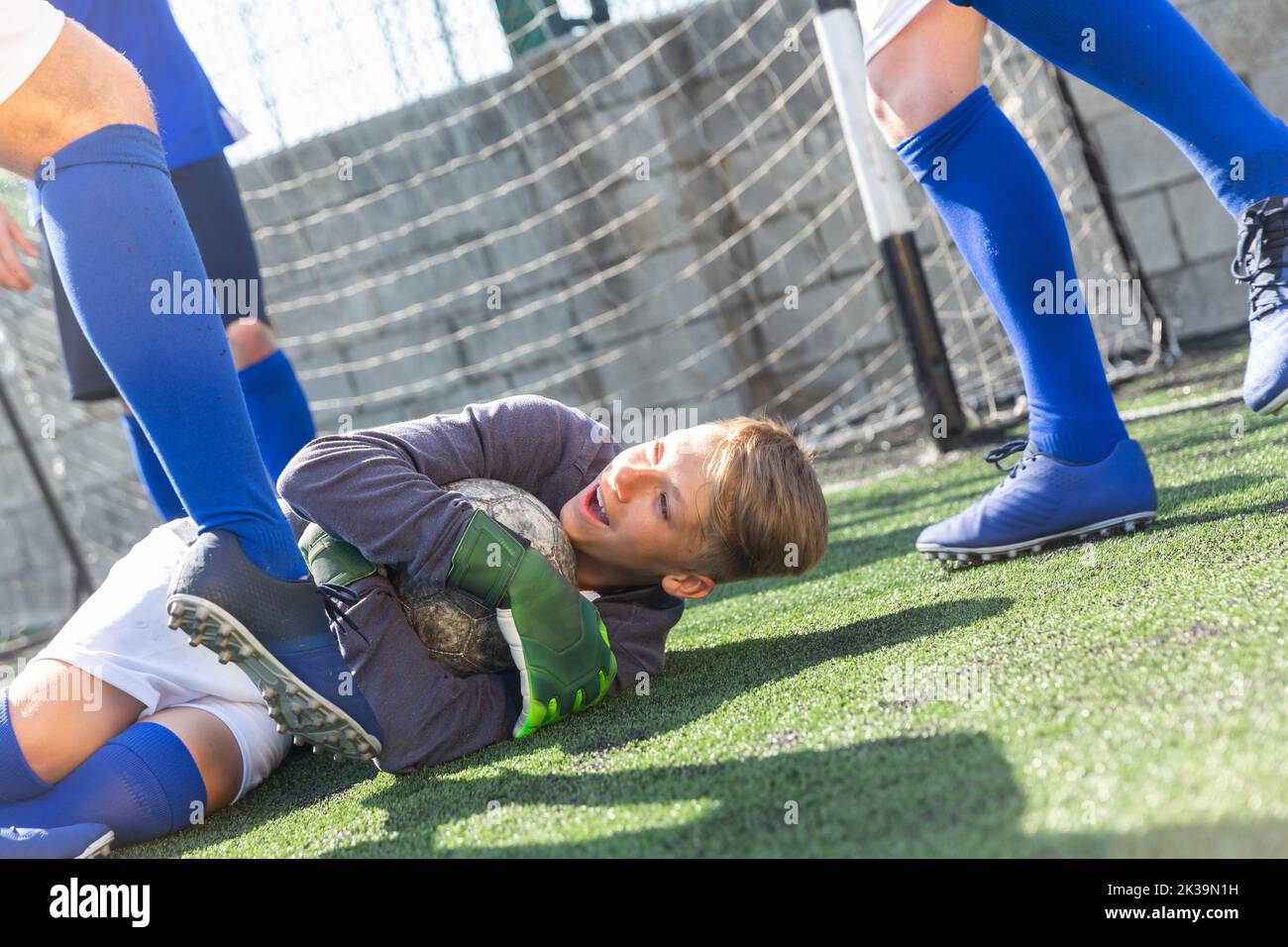 Goalkeeper catches ball in the penalty area. Young teen soccer game