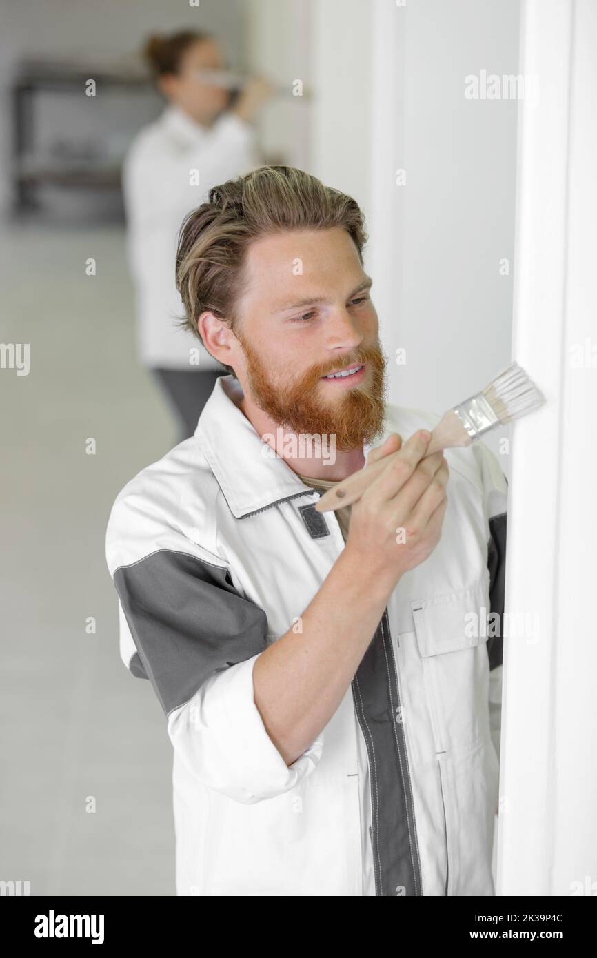 professional painter redecorating a wall using a paintbrush Stock Photo