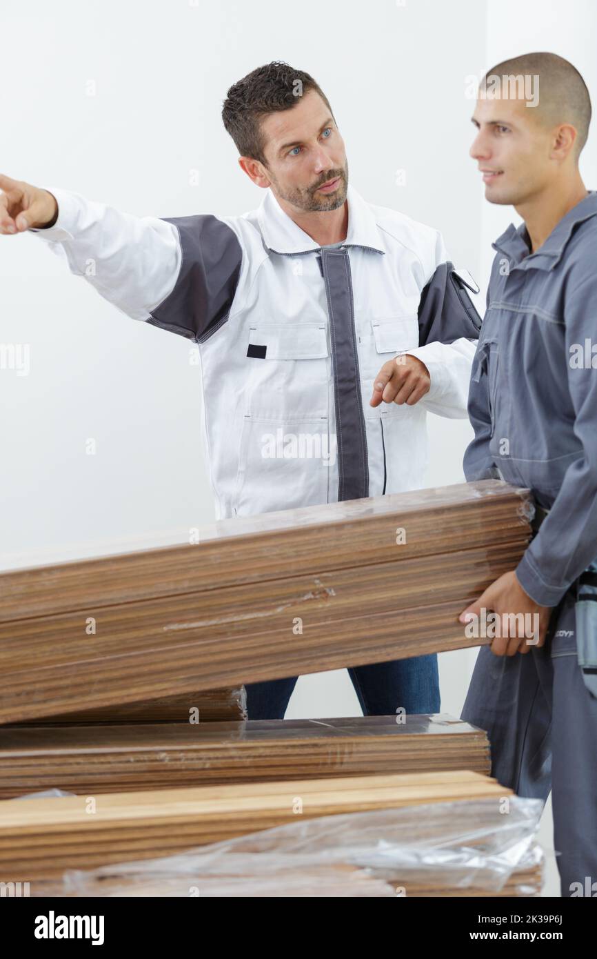 serious male carpenter showing something to coworker Stock Photo