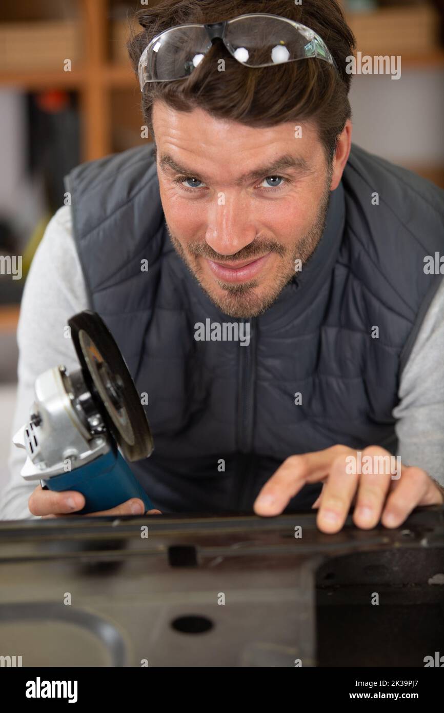 workman using an angle grinder on a car door Stock Photo Alamy