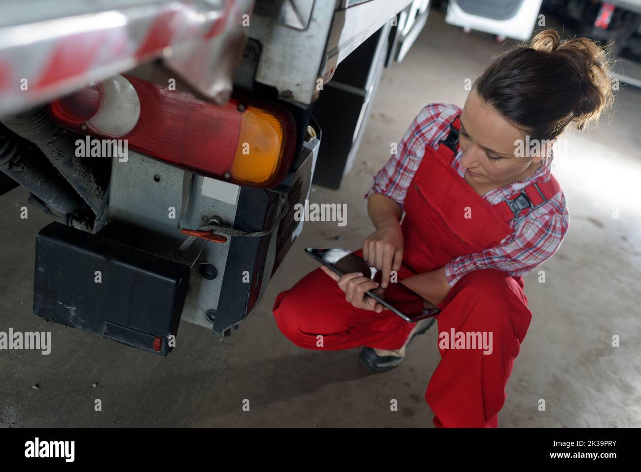female truck mechanic using tablet pc Stock Photo