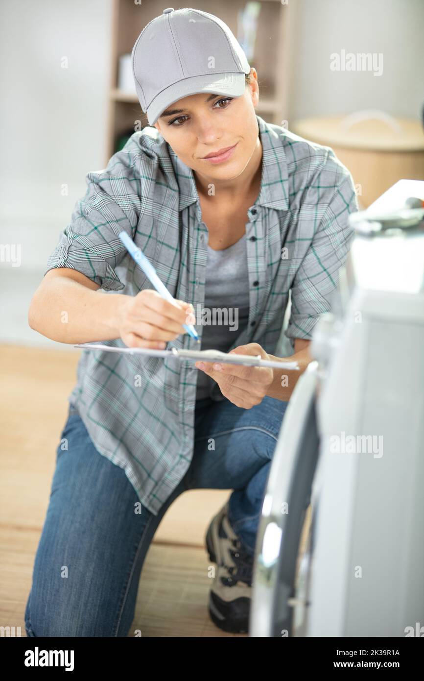 young lady repairing a washing machine Stock Photo - Alamy
