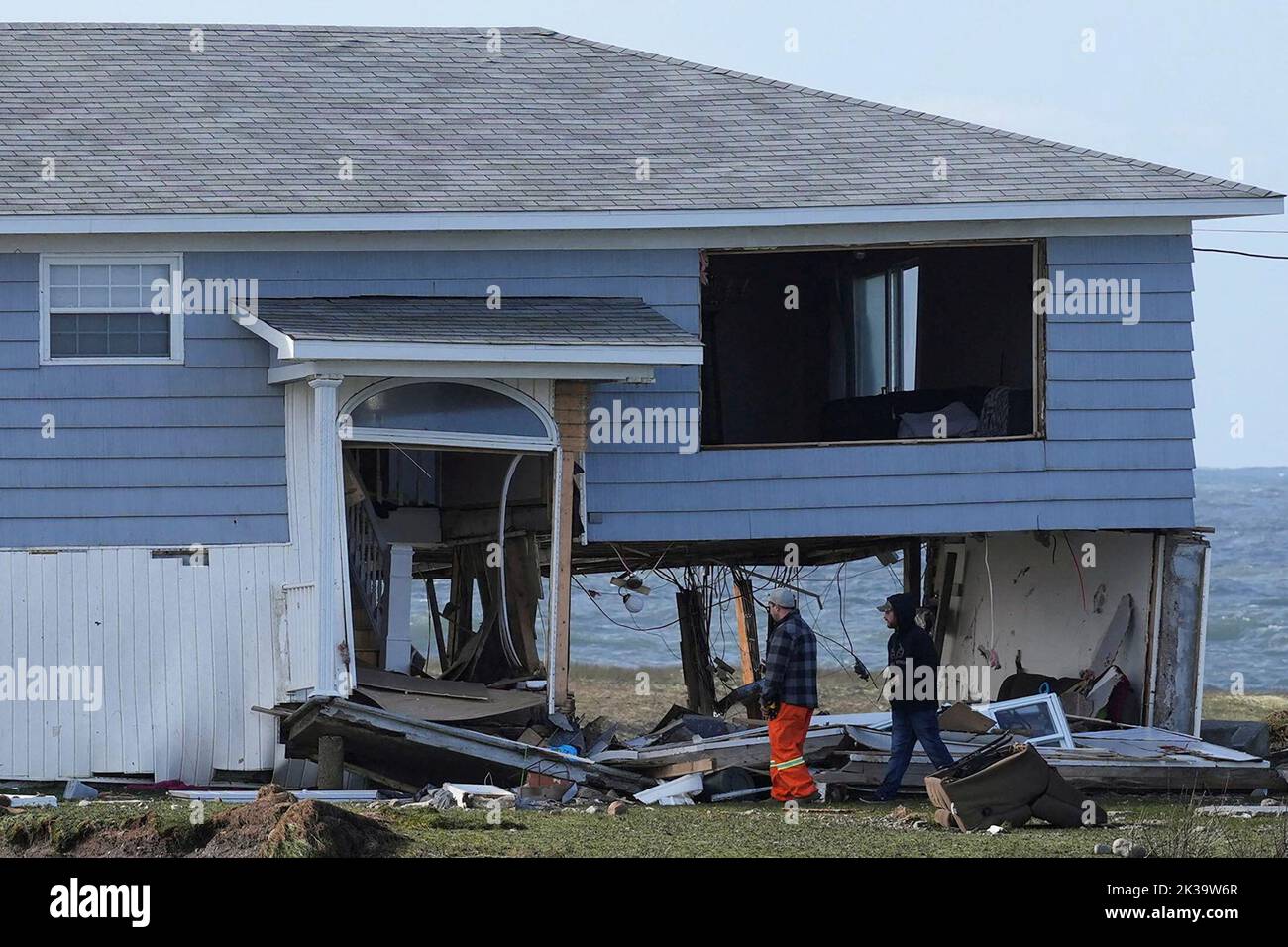 People examine a house after the arrival of Hurricane Fiona in Port Aux Basques, Newfoundland, Canada September 25, 2022. REUTERS/John Morris Stock Photo