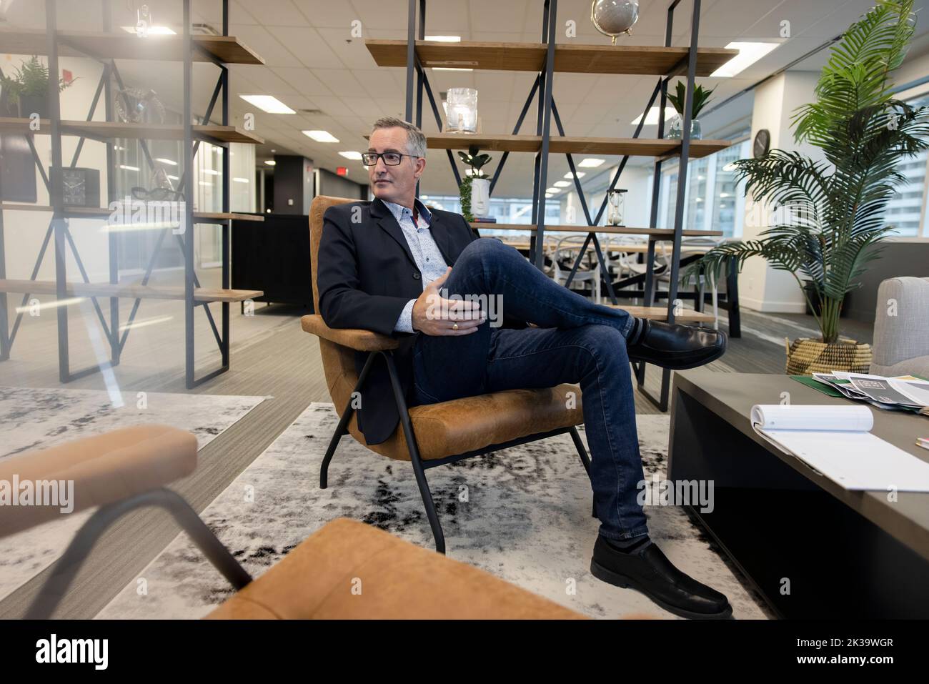 Project manager sitting on armchair in breakout space Stock Photo