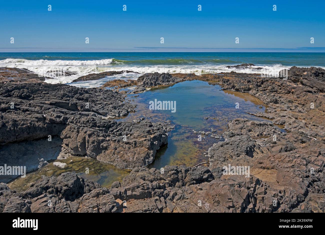 Tidepools in the Rocks Amidst Crashing Waves on Cape Perpetua in Oregon Stock Photo