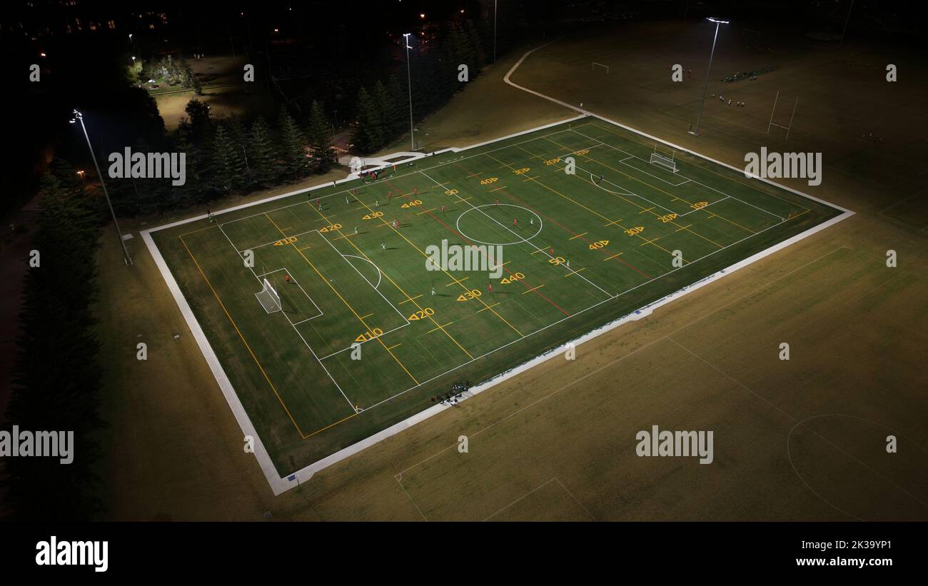 An aerial view of a rugby field surrounded by bright lights in the