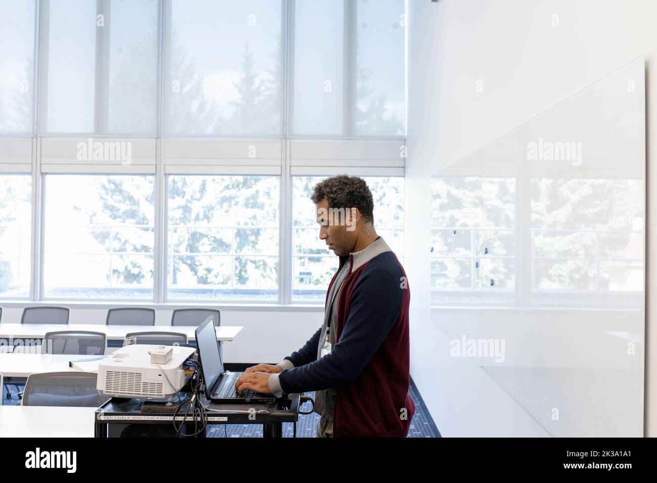 Male college professor using laptop in classroom Stock Photo Alamy