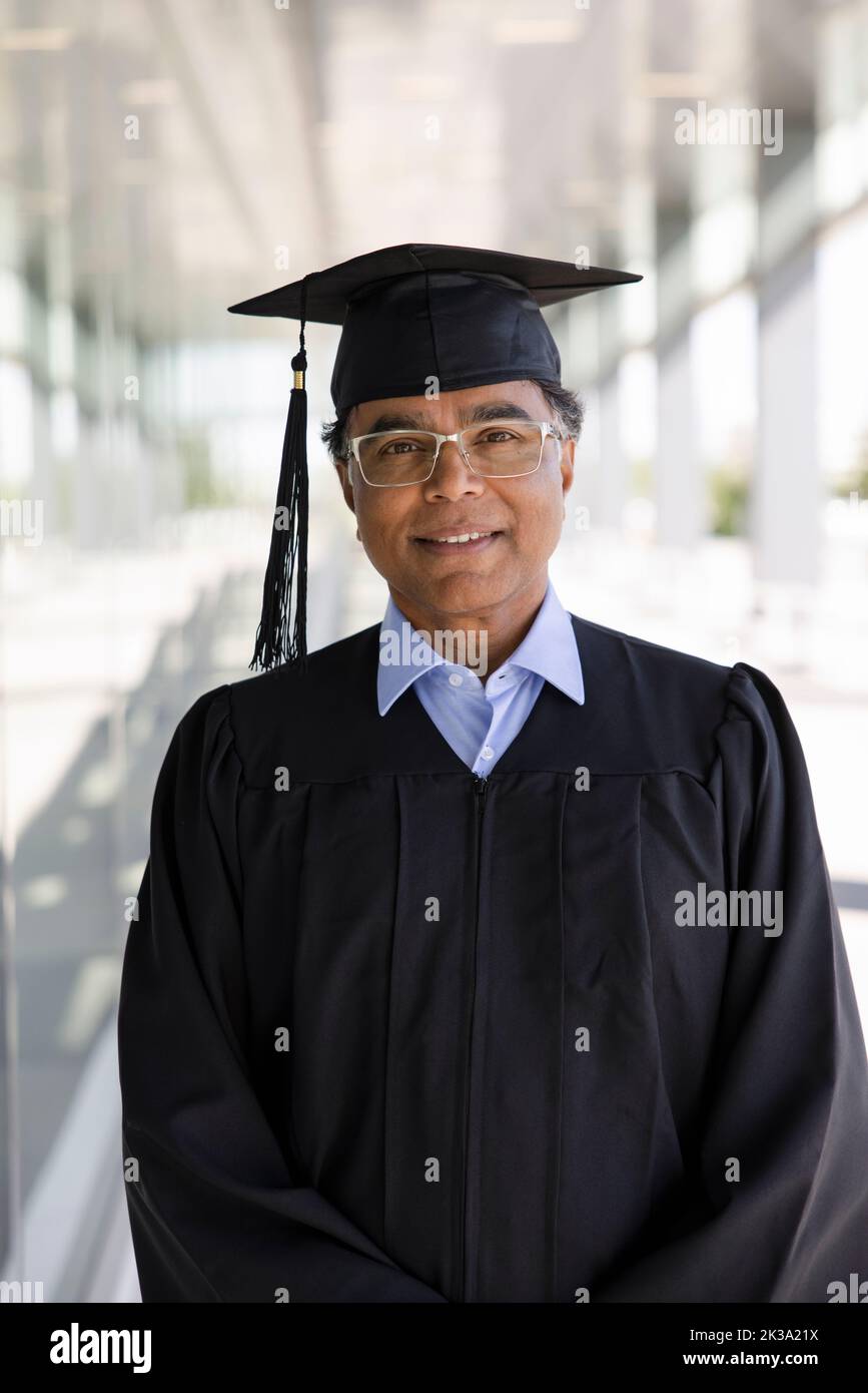 Portrait confident mature male college graduate in cap and gown Stock