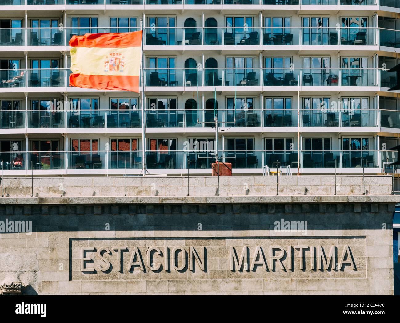 Vigo, Spain - September 25, 2022: View of sign to maritime station with pattern of cabins from a cruise ship next to a Spanish flag Stock Photo