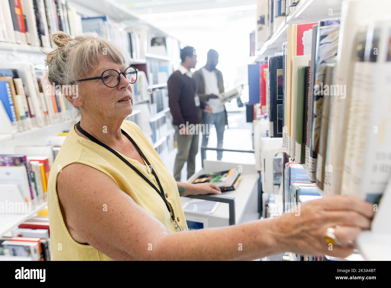 Female librarian shelving books at library bookshelf Stock Photo Alamy