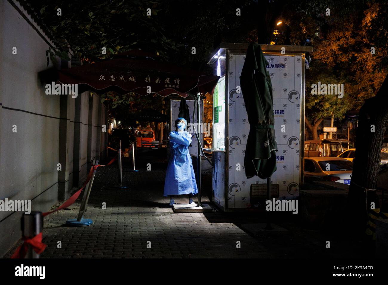 A pandemic prevention worker in a protective suit stands outside a nucleic acid testing station, set up citywide to trace possible coronavirus disease (COVID-19) outbreaks in Beijing, China, September 19, 2022. REUTERS/Thomas Peter Stock Photo