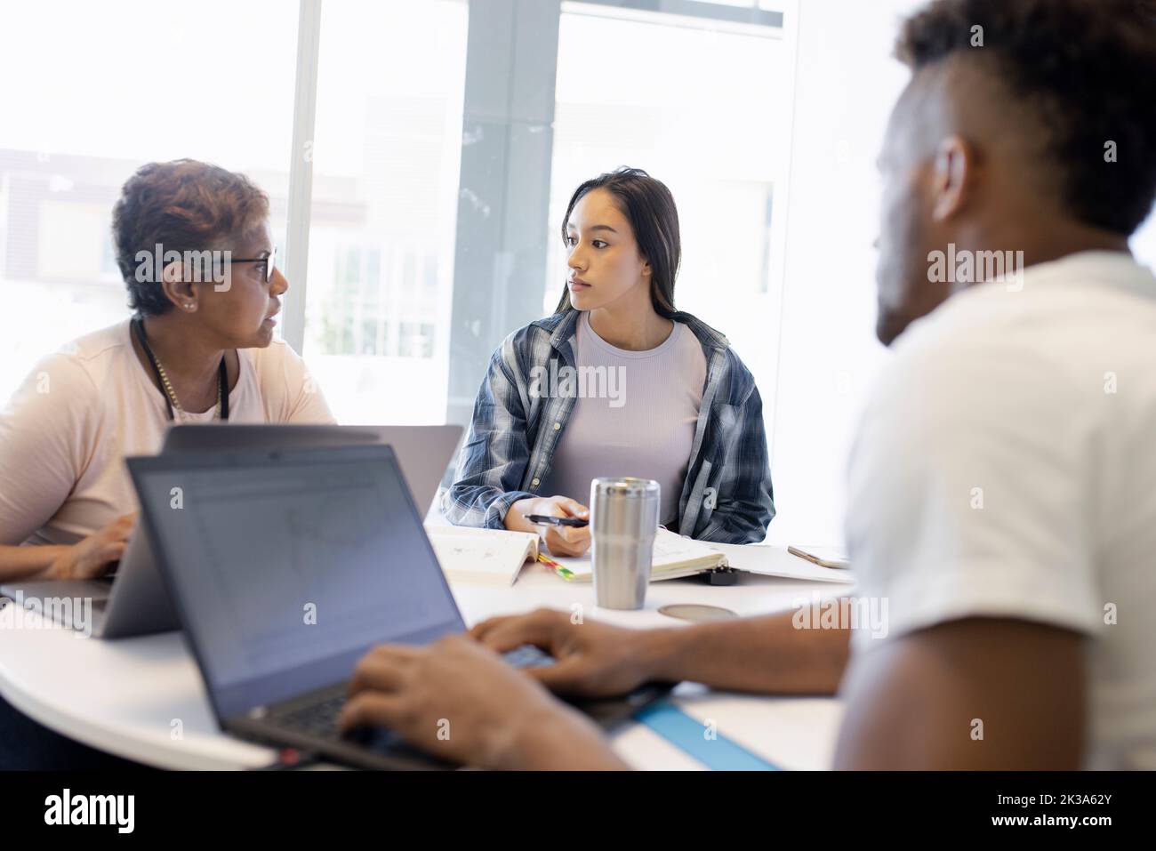 Tutor helping college students Stock Photo