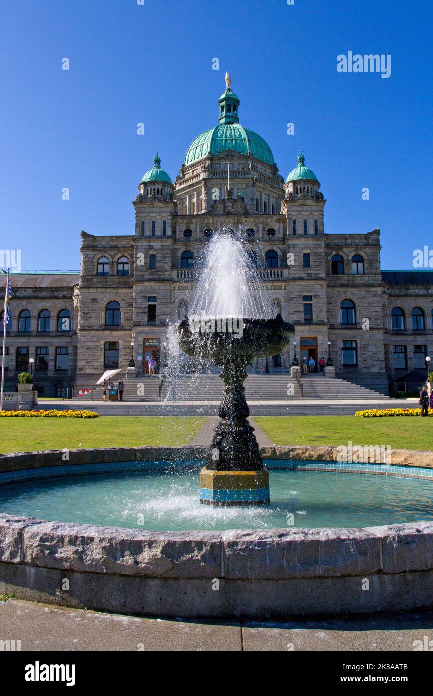 A scenic view of the British Columbia Parliament Buildings in Victoria, British Columbia, Canada, with the water fountain close-up in the foreground. Stock Photo