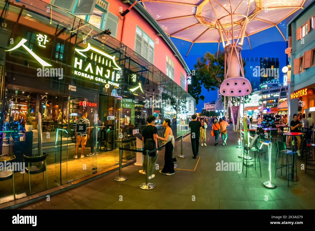 Street view of lighted Clarke Quay in historic riverside quay, famous