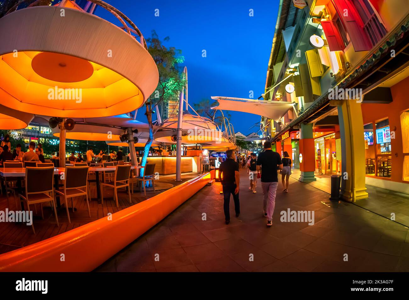 Street view of lighted Clarke Quay in historic riverside quay, famous