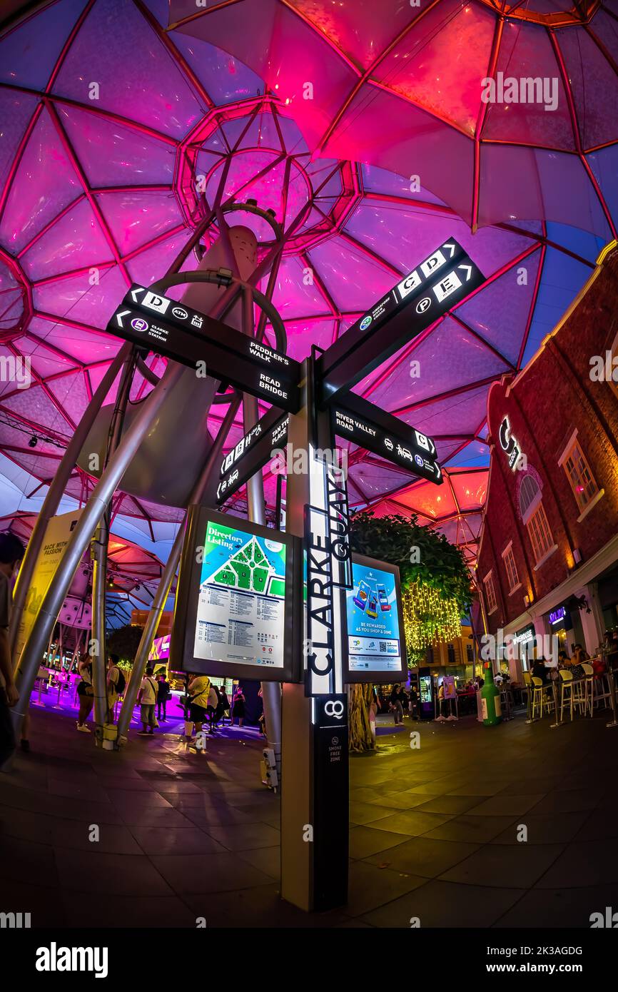 Street view of lighted Clarke Quay in historic riverside quay, famous