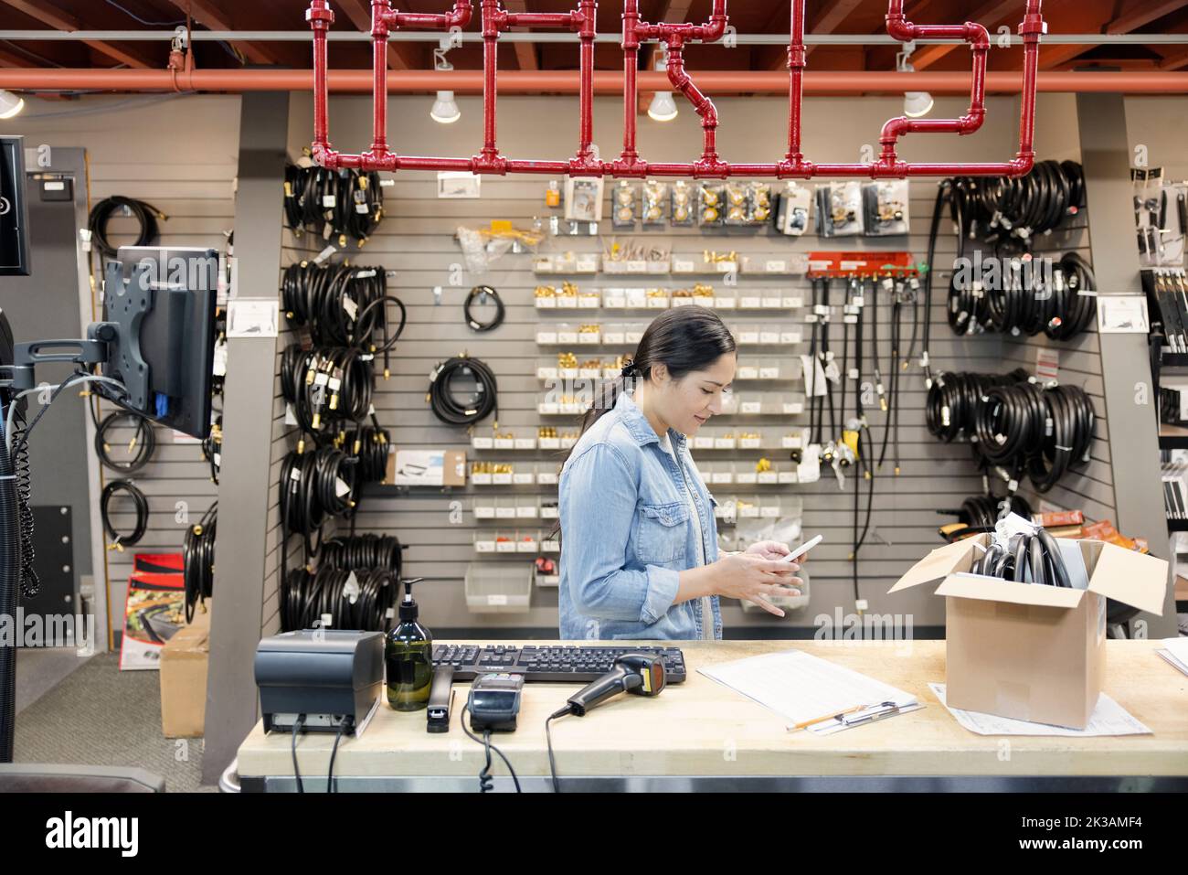 Store worker using phone at service counter Stock Photo Alamy