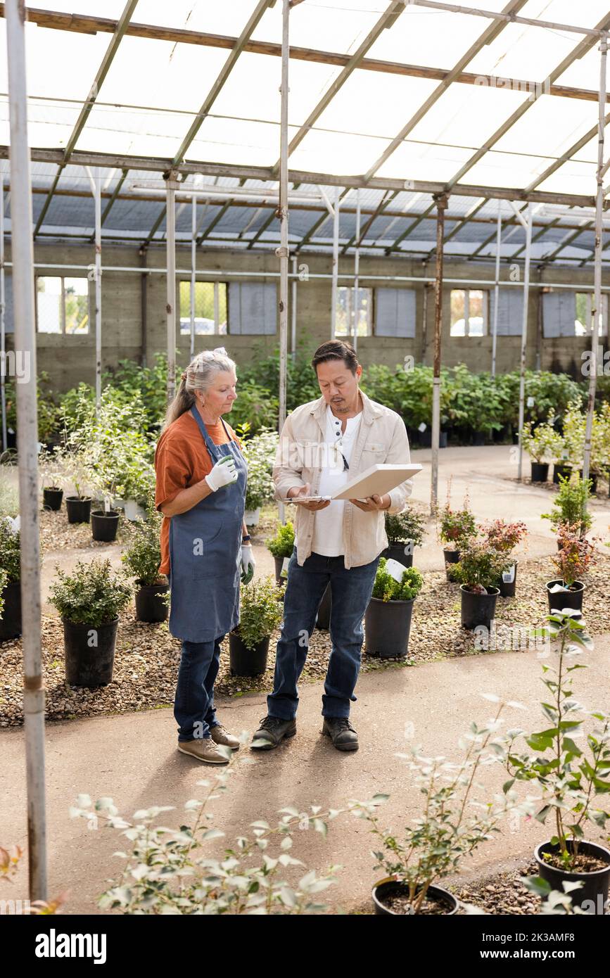 business partners discussing work in garden center Stock Photo