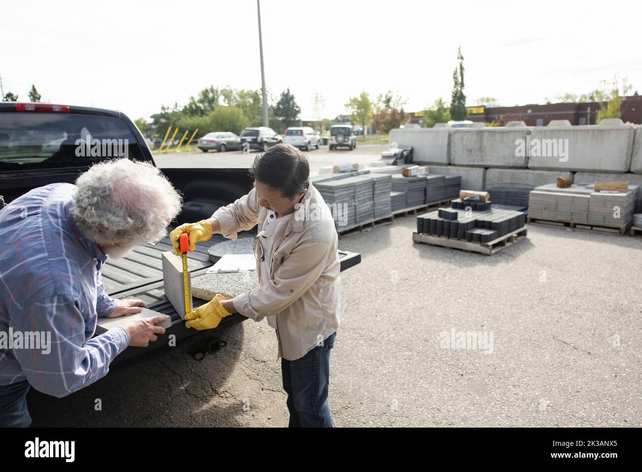 Senior owner measuring cement block for customer at car rear Stock Photo Alamy