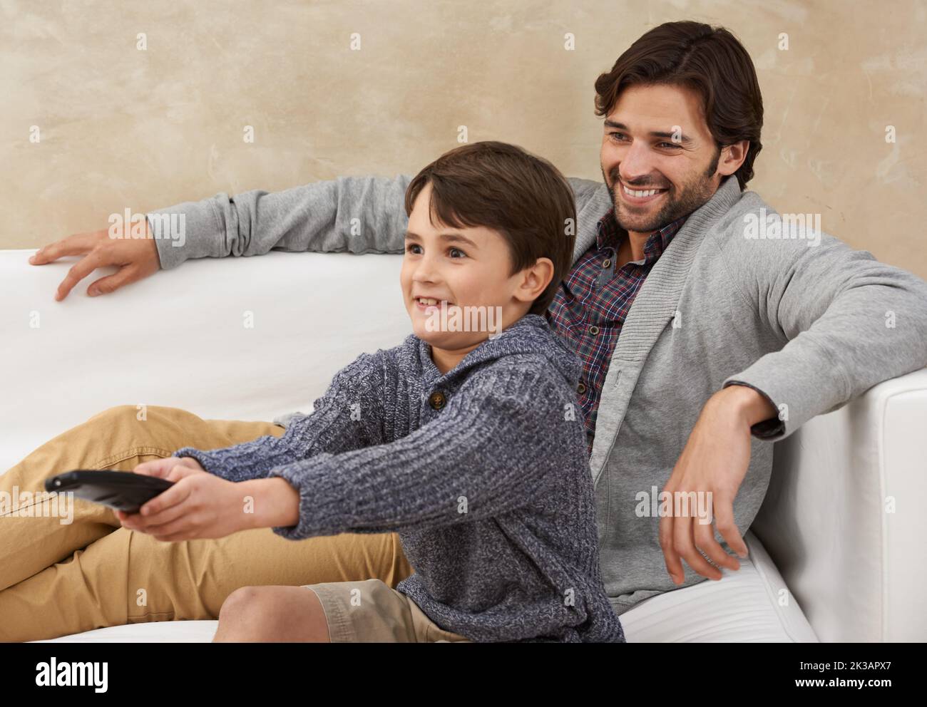I get to choose the channel this time. father and son enjoying some quality time together. Stock Photo